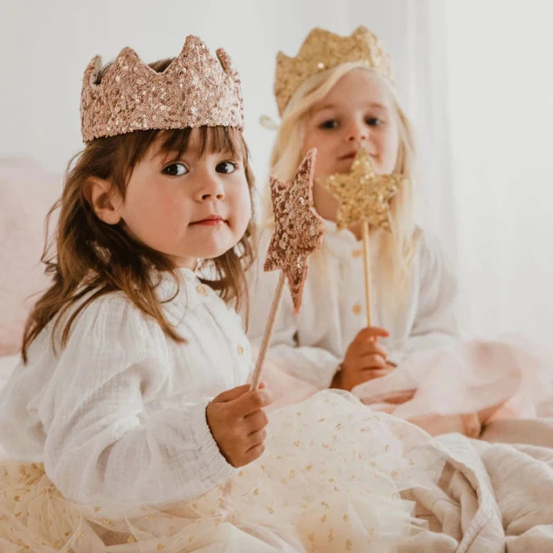 C'est l'accessoire indispensable des fées en herbe ! On l'associe à la couronne en sequins dorés et une jolie cape en tulle et vous voilà parée pour allumer les étoiles ! Ornée d'une étoile pailletée rose ou or. Longueur : 40 cm