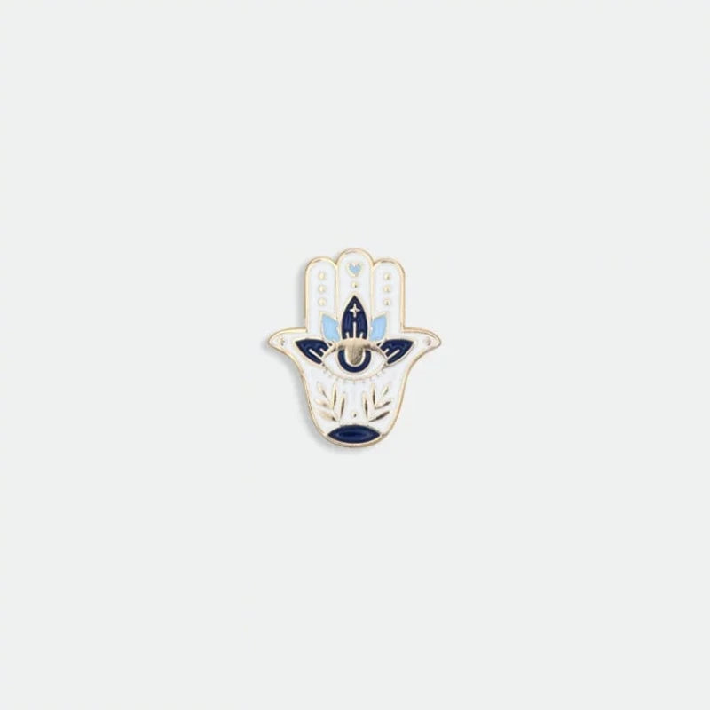 Avec humour et style, la marque All The Ways To Say arbore un design unique et décalé, toujours très coloré. Découvrez ce magnifique pin’s Fatma représentant une main bleutée avec un œil au centre dans un lotus afin d’ éloigner le mauvais œil. La marque française All The Ways To Say est une marque féminine et colorée !