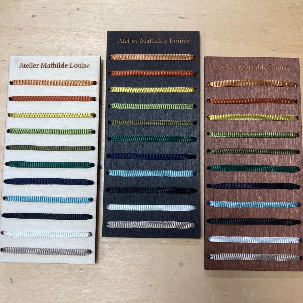 Présentation des couleurs de bois chêne clair, teck et ébène de gauche à droite avec pour chaque essence 11 coloris de tissage.
