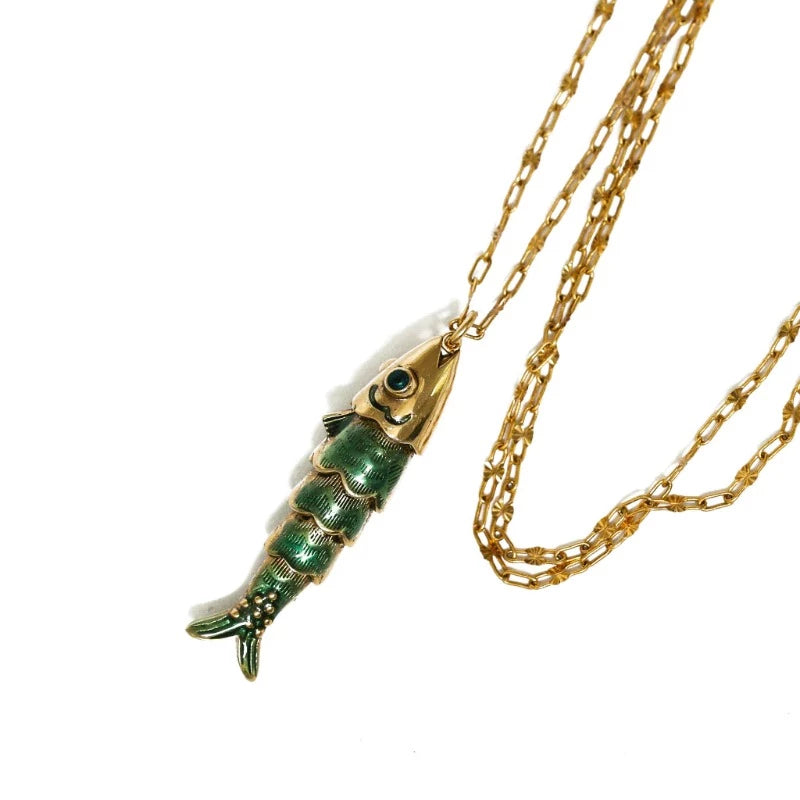 Collier Sacha poisson articulé avec yeux émaillés et les écailles émaillées en bleu transparent. Laiton bain d’or. Longueur de la chaîne 55 cm, longueur du poisson 4 cm.