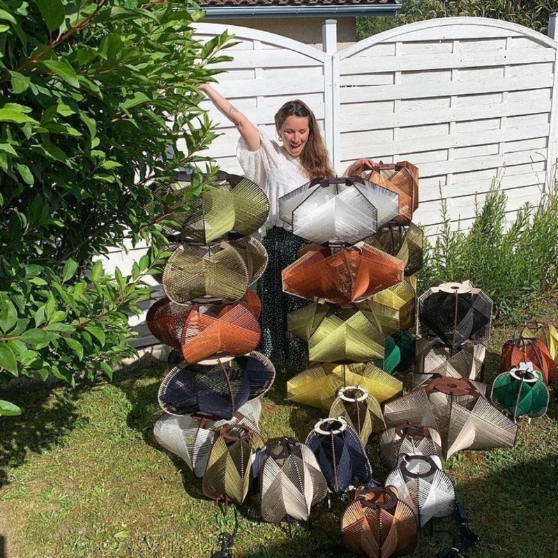 La créatrice Mathilde de L’Atelier Mathilde Louise et ses créations de suspensions et lampes à poser dans son jardin.