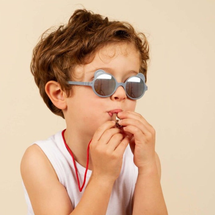 L'iconique paire de lunettes aux petites oreilles, fabriquée en France, en forme d'ourson. Ergonomiques, très légères et douces. Aucune pression sur les tempes ou sur l’arête du nez ni d’écrasement des oreilles de bébé. Déclinée en coloris mixtes et tendances : crème, rose pêche, bleu argenté, bleu ciel Ourson Baby est disponible pour les bouts de chou dès 3 mois, avec des verres de catégorie 3 filtrant 100% des UV.