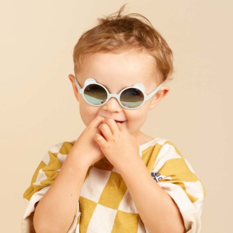L'iconique paire de lunettes aux petites oreilles, fabriquée en France, en forme d'ourson. Ergonomiques, très légères et douces. Aucune pression sur les tempes ou sur l’arête du nez ni d’écrasement des oreilles de bébé. Déclinée en coloris mixtes et tendances : crème, rose pêche, bleu argenté, bleu ciel Ourson Baby est disponible pour les bouts de chou dès 3 mois, avec des verres de catégorie 3 filtrant 100% des UV.