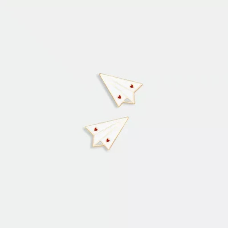 Avec humour et style, la marque All The Ways To Say arbore un design unique et décalé, toujours très coloré.   Découvrez ce magnifique pin’s représentant deux avions en papier blanc avec deux petits cœurs rouges sur les ailes.  La marque française All The Ways To Say est une marque féminine et colorée !