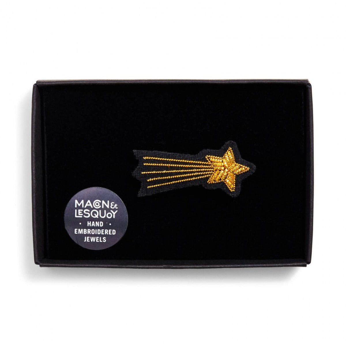 Broche brodée à la main de la marque Macon et Lesquoy. Cette broche de couleur dorée représente l'étoile filante Méliès.