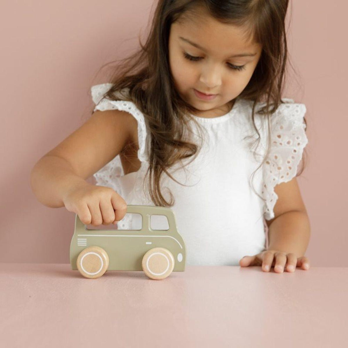 Petite fille faisant rouler sa camionnette vert olive de la collection Little Goose de Little Dutch.