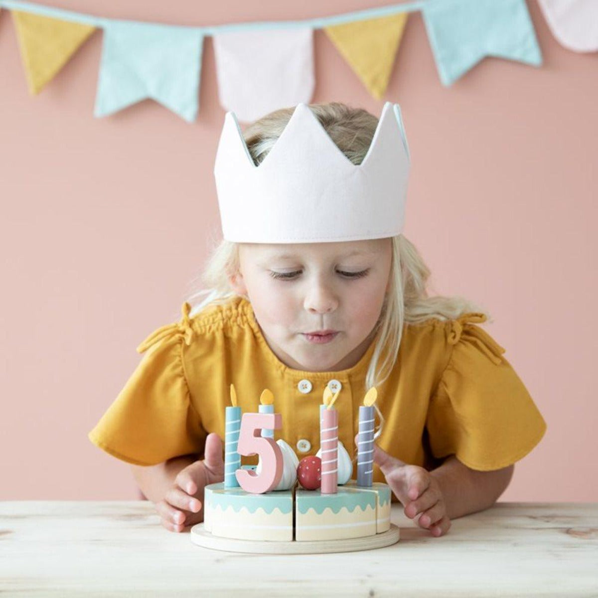 Visuel une petite fille souffle ses bougies pour ses 5 ans. gateau d'anniversaire de la marque Little Dutch.