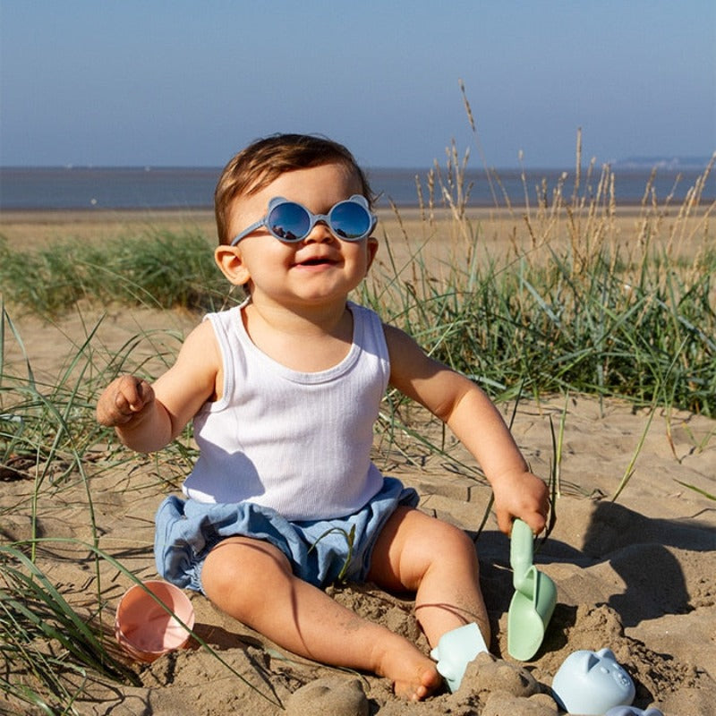 L'iconique paire de lunettes aux petites oreilles, fabriquée en France, en forme d'ourson.  Ergonomiques, très légères et douces. Aucune pression sur les tempes ou sur l’arête du nez ni d’écrasement des oreilles de bébé.  Déclinée en coloris mixtes et tendances : crème, rose pêche, bleu argenté, bleu ciel  Ourson Baby est disponible pour les bouts de chou dès 3 mois, avec des verres de catégorie 3 filtrant 100% des UV.